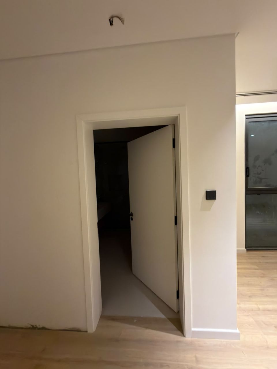 Run of white hidden doors along a corridor, Meydan District One