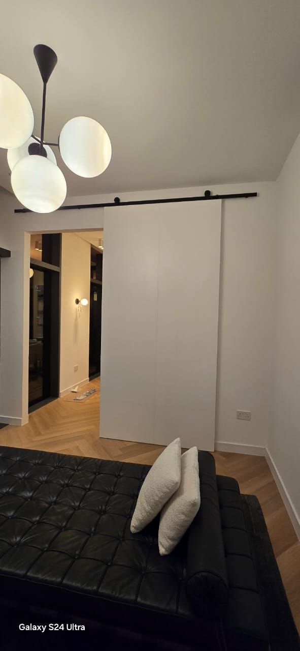 White sliding door on a black rail, Downtown Dubai apartment