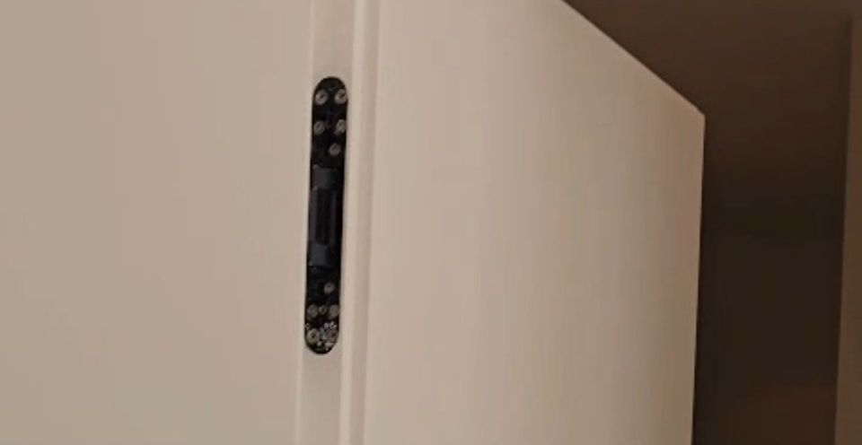 Black lever on a white hidden door, close