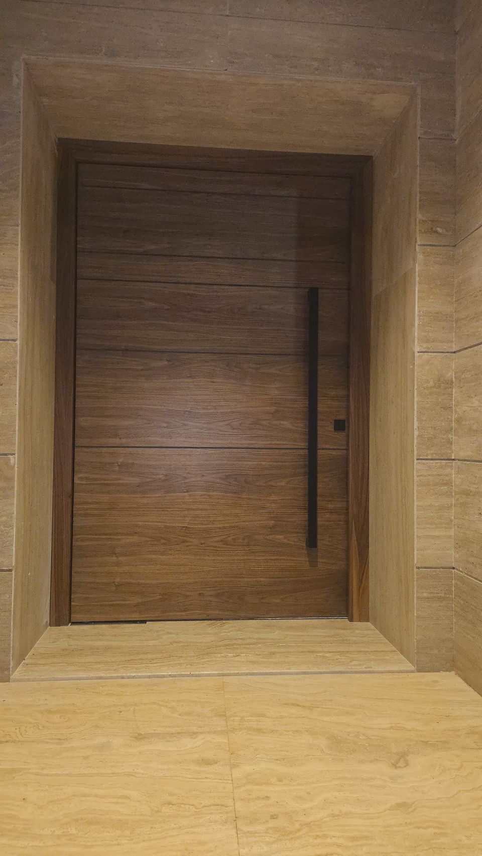 Walnut Grooved Pivot Door In Travertine Surround